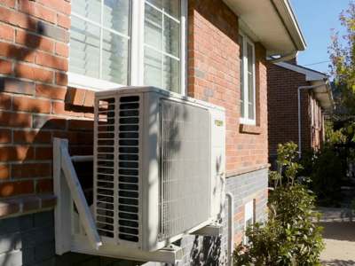 Modern residential air conditioning outdoor unit installed beside a home exterior.